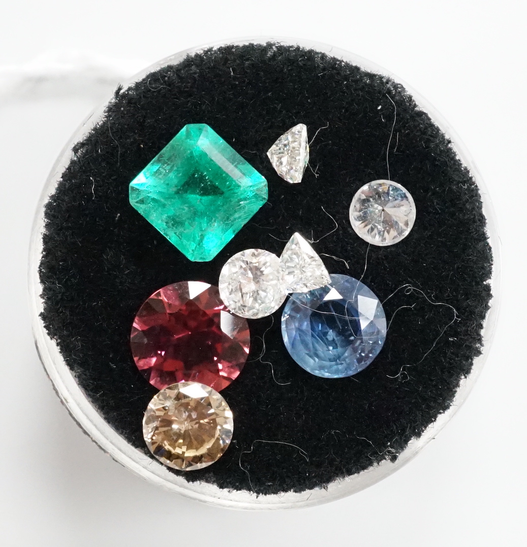 Eight assorted unmounted cut gemstones, including emerald and diamond.